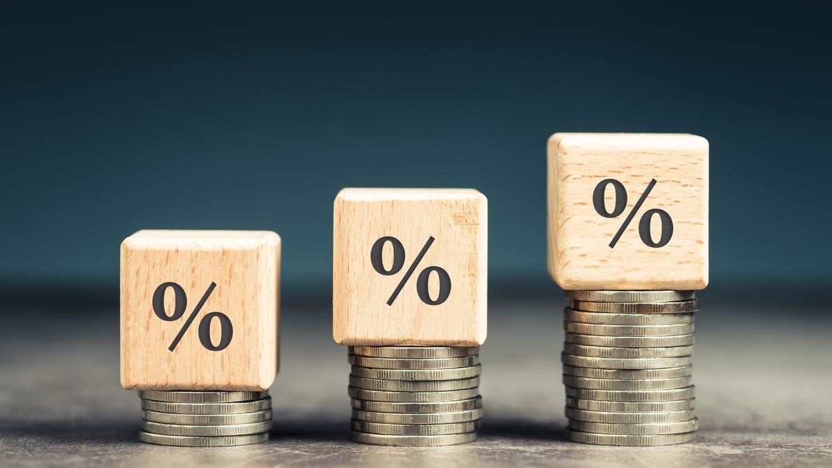 Three percentage signs on top of three coin stacks